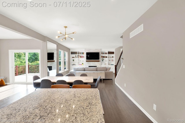 2962 Iowa Dr, Troy, MI 48083 - living area featuring a fireplace, a chandelier, dark wood-style flooring, built in features, and stairway