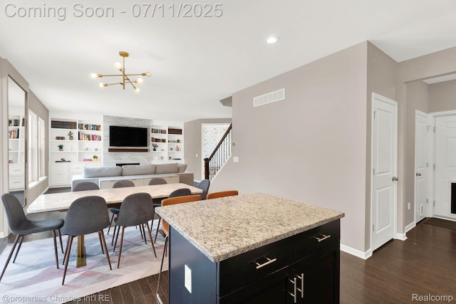 2962 Iowa Dr, Troy, MI 48083 - kitchen featuring dark wood finished floors, a chandelier, dark cabinetry, a fireplace, and recessed lighting
