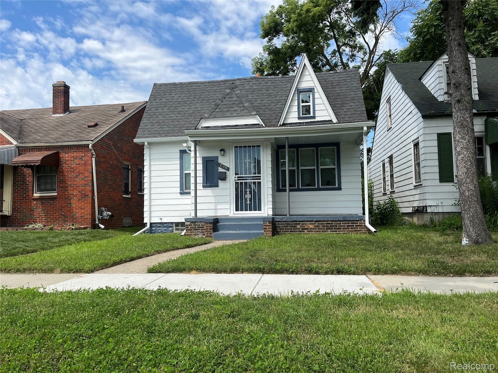 19309 Carrie St, Detroit, MI 48234 - bungalow with a front yard, roof with shingles, and a porch