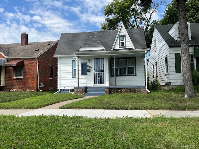 19309 Carrie St, Detroit, MI 48234 - bungalow with a front yard, roof with shingles, and a porch