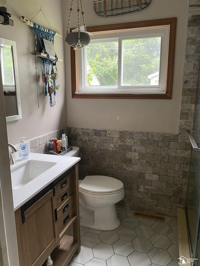 15427 Keegan Rd, Monroe, MI 48161 - bathroom featuring tile walls, vanity, a wainscoted wall, and tile patterned flooring