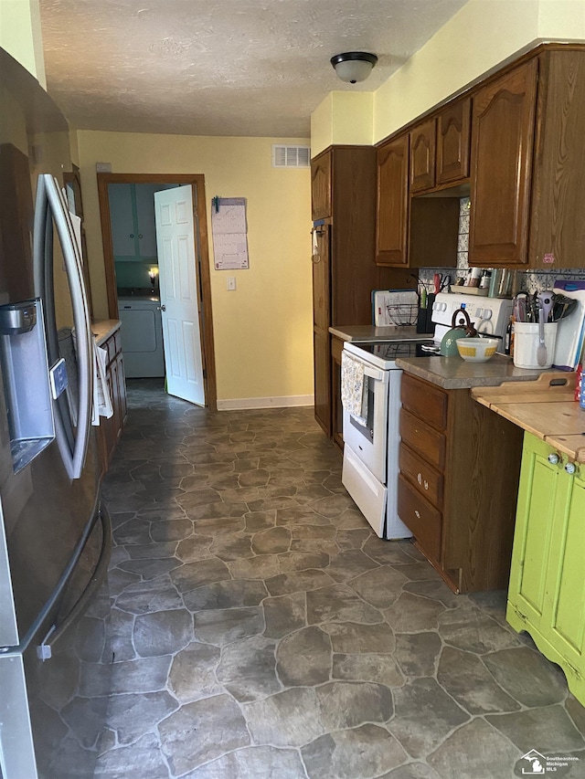 15427 Keegan Rd, Monroe, MI 48161 - kitchen featuring stainless steel fridge, white electric range oven, stone flooring, a textured ceiling, and washer / clothes dryer