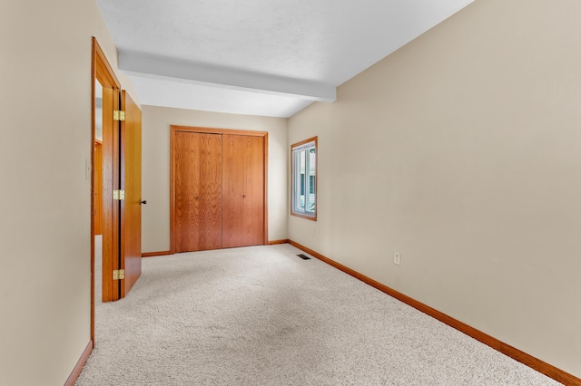 22100 N Uldriks Dr, Battle Creek, MI 49017 - unfurnished bedroom featuring carpet, a closet, and beam ceiling