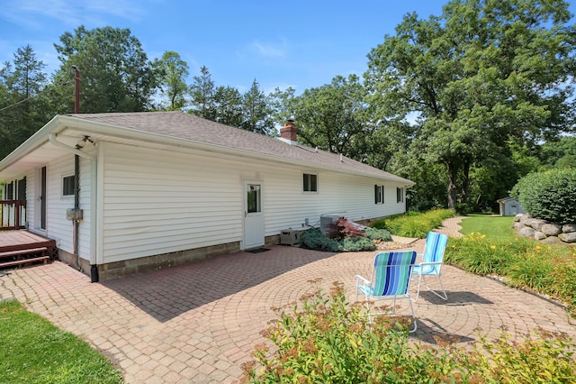 22100 N Uldriks Dr, Battle Creek, MI 49017 - rear view of property featuring a patio area, a chimney, a shed, and roof with shingles