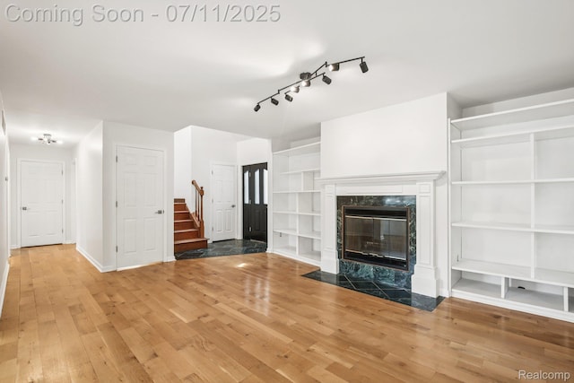 10746 Winthrop, Pinckney, MI 48169 - unfurnished living room featuring stairs, wood finished floors, track lighting, and a fireplace