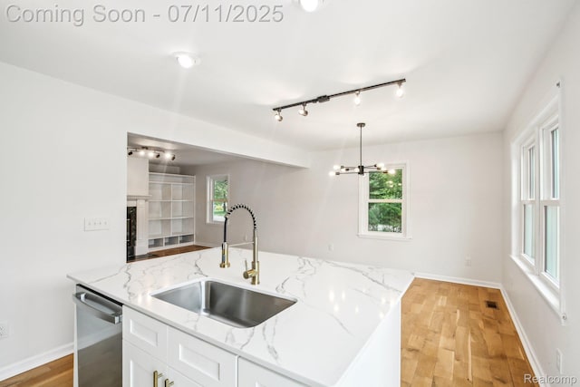 10746 Winthrop, Pinckney, MI 48169 - kitchen with stainless steel dishwasher, rail lighting, a chandelier, white cabinetry, and light wood finished floors