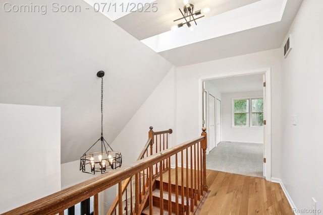 10746 Winthrop, Pinckney, MI 48169 - hall featuring a chandelier, an upstairs landing, and light wood-style floors