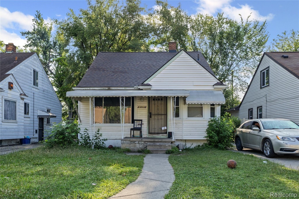 18936 Gilchrist St, Detroit, MI 48235 - bungalow-style home with a front lawn, a chimney, and roof with shingles