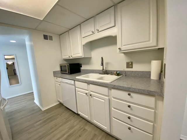 18220 University Park Dr, Livonia, MI 48152 - kitchen with stainless steel microwave, white dishwasher, white cabinets, light wood-type flooring, and a drop ceiling