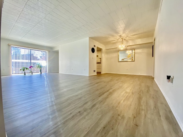 18220 University Park Dr, Livonia, MI 48152 - unfurnished living room featuring wood finished floors and a chandelier