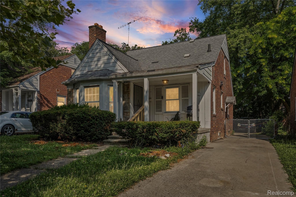 11601 Nottingham Rd, Detroit, MI 48224 - bungalow-style house featuring a chimney, a shingled roof, brick siding, and concrete driveway