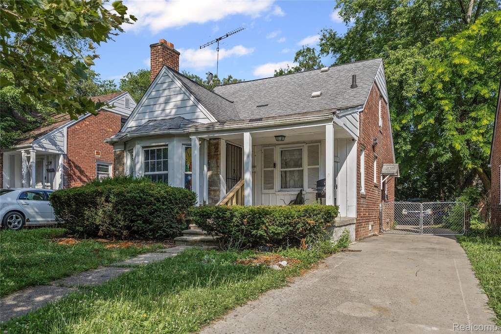 11601 Nottingham Rd, Detroit, MI 48224 - bungalow with a chimney, brick siding, roof with shingles, and a gate