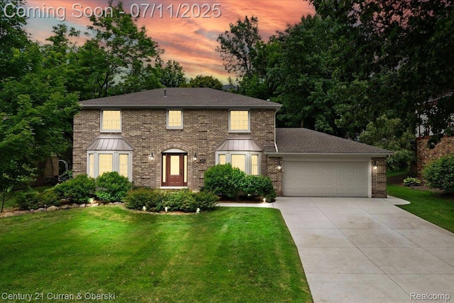 42369 Crestview Cir, Northville, MI 48168 - view of front of home featuring an attached garage, concrete driveway, a lawn, and brick siding