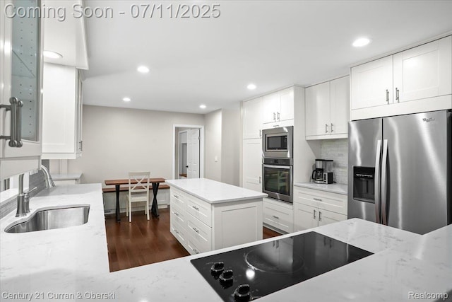 42369 Crestview Cir, Northville, MI 48168 - kitchen with appliances with stainless steel finishes, dark wood finished floors, recessed lighting, white cabinets, and light stone counters