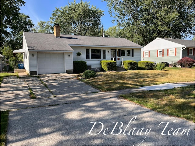 1056 Sherwood Rd, Muskegon, MI 49441 - view of front facade featuring a garage, a chimney, driveway, and a front lawn