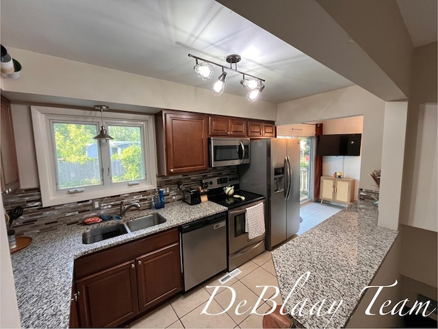 1056 Sherwood Rd, Muskegon, MI 49441 - kitchen featuring stainless steel appliances, light tile patterned flooring, tasteful backsplash, and plenty of natural light