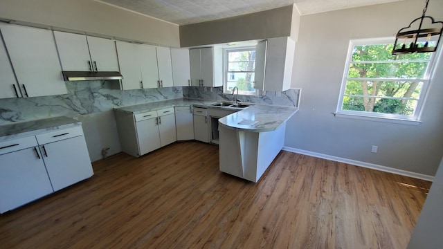 2031 Baker St, Muskegon, MI 49444 - kitchen featuring a peninsula, tasteful backsplash, dark wood-style flooring, under cabinet range hood, and white cabinets