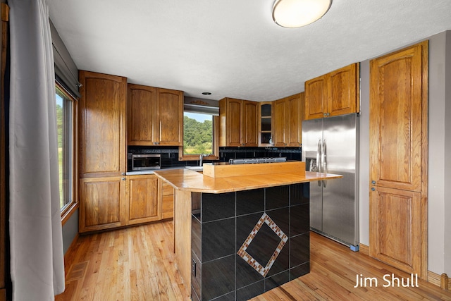 8201 Crocker Rd, Holton, MI 49425 - kitchen featuring appliances with stainless steel finishes, brown cabinets, and light wood-style floors