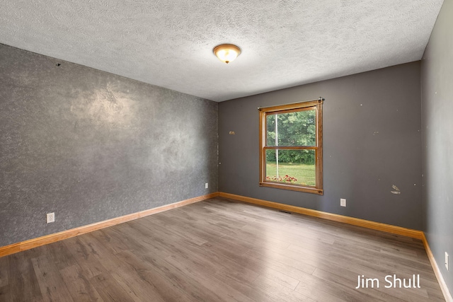 8201 Crocker Rd, Holton, MI 49425 - empty room with wood finished floors and a textured ceiling