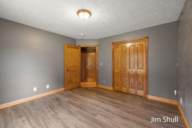8201 Crocker Rd, Holton, MI 49425 - unfurnished bedroom with wood finished floors, a textured ceiling, and a closet