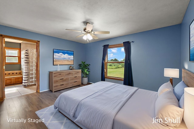 8201 Crocker Rd, Holton, MI 49425 - bedroom featuring wood finished floors, ensuite bathroom, and ceiling fan