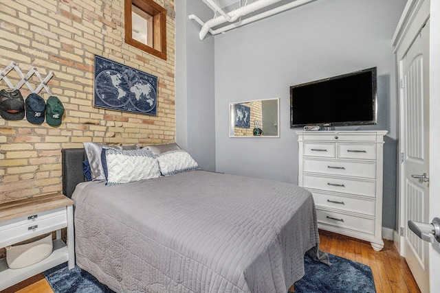 600 Broadway Ave NW Unit 402, Grand Rapids, MI 49504 - bedroom featuring light wood-style flooring and brick wall
