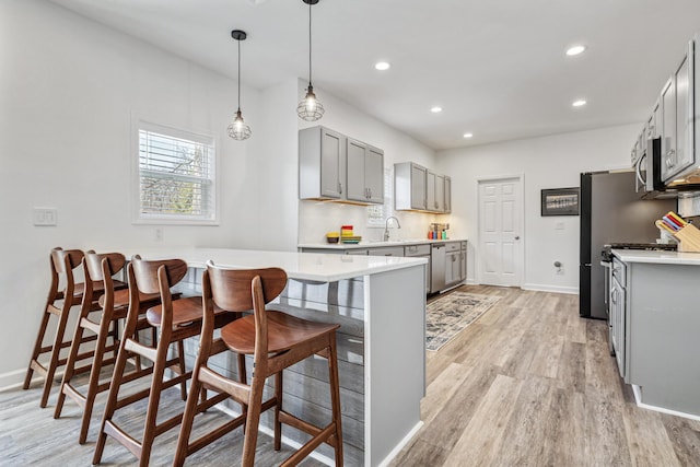 32 Walden Way, New Buffalo, MI 49117 - kitchen with gray cabinets, light countertops, light wood-style flooring, a kitchen bar, and recessed lighting