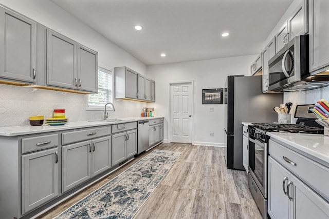 32 Walden Way, New Buffalo, MI 49117 - kitchen featuring appliances with stainless steel finishes, gray cabinetry, light wood-type flooring, decorative backsplash, and recessed lighting