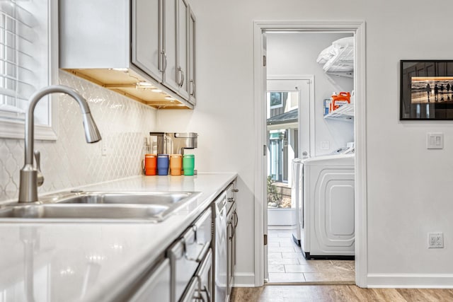 32 Walden Way, New Buffalo, MI 49117 - kitchen with light countertops, tasteful backsplash, stainless steel dishwasher, washer and dryer, and gray cabinets