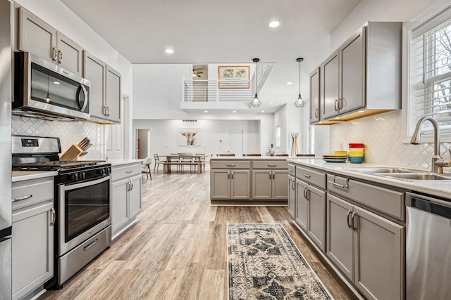 32 Walden Way, New Buffalo, MI 49117 - kitchen with stainless steel appliances, gray cabinets, decorative backsplash, light wood finished floors, and light countertops
