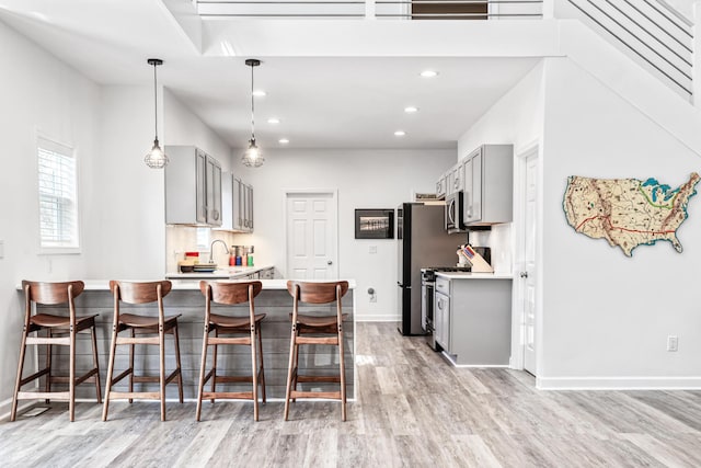 32 Walden Way, New Buffalo, MI 49117 - kitchen with gray cabinetry, stainless steel appliances, light countertops, light wood finished floors, and a peninsula