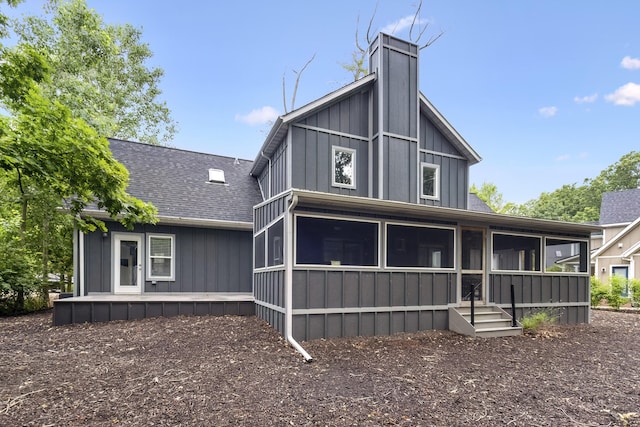 32 Walden Way, New Buffalo, MI 49117 - back of property featuring a sunroom, board and batten siding, a chimney, and roof with shingles