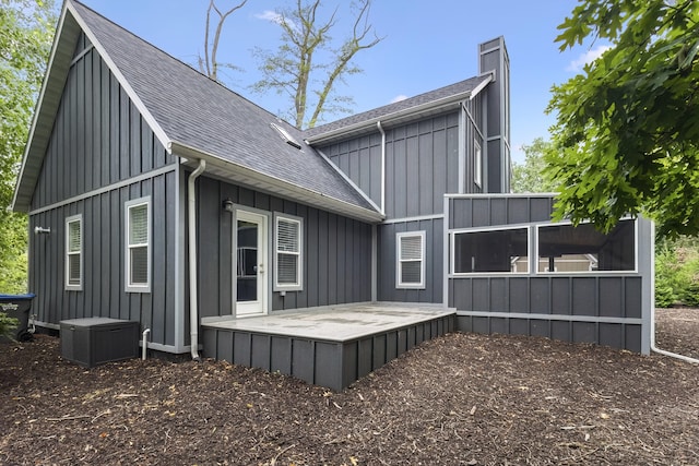 32 Walden Way, New Buffalo, MI 49117 - back of house featuring a shingled roof, a chimney, board and batten siding, and a patio