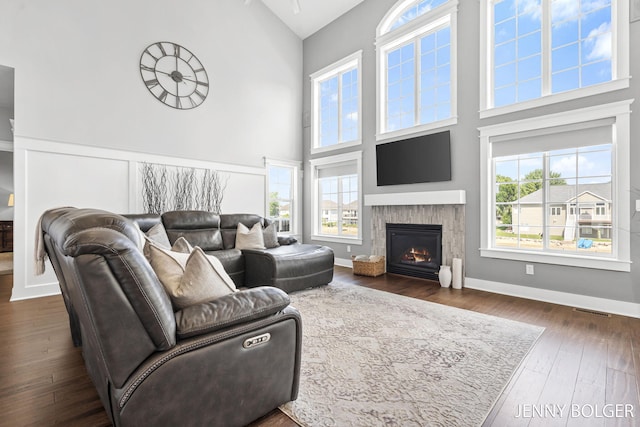 7066 Country Springs Dr SW, Byron Center, MI 49315 - living area featuring high vaulted ceiling, a warm lit fireplace, and dark wood-style floors