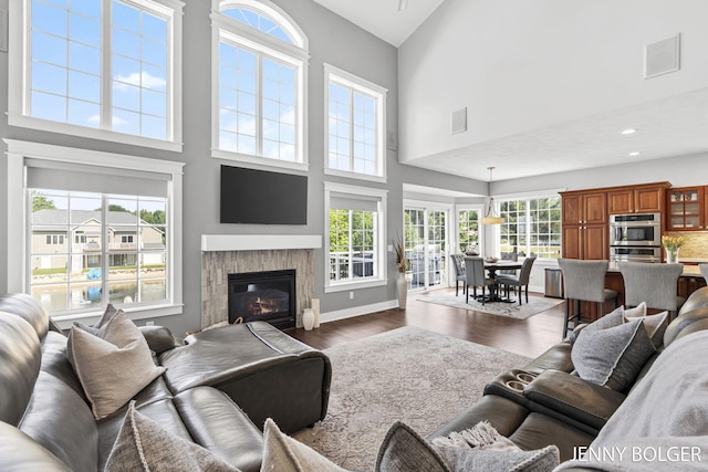 7066 Country Springs Dr SW, Byron Center, MI 49315 - living area with a towering ceiling, dark wood-type flooring, a glass covered fireplace, and recessed lighting