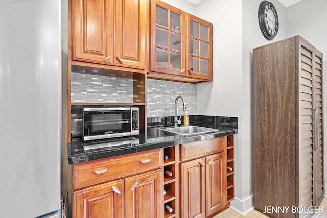 7066 Country Springs Dr SW, Byron Center, MI 49315 - kitchen featuring stainless steel appliances, decorative backsplash, glass insert cabinets, and brown cabinets