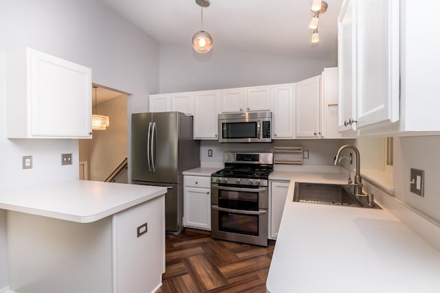 266 Westover Ave, Ann Arbor, MI 48103 - kitchen featuring appliances with stainless steel finishes, vaulted ceiling, light countertops, white cabinetry, and a peninsula