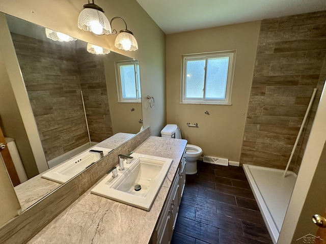 4650 Village Dr, Saginaw, MI 48638 - bathroom featuring vanity, a tile shower, and wood finished floors