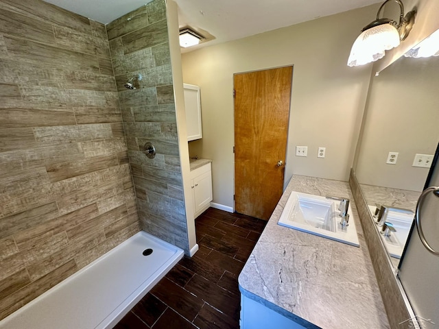 4650 Village Dr, Saginaw, MI 48638 - full bathroom featuring vanity, tiled shower, and wood tiled floors