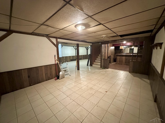 4650 Village Dr, Saginaw, MI 48638 - finished basement with wood walls, stairway, a drop ceiling, wainscoting, and bar area