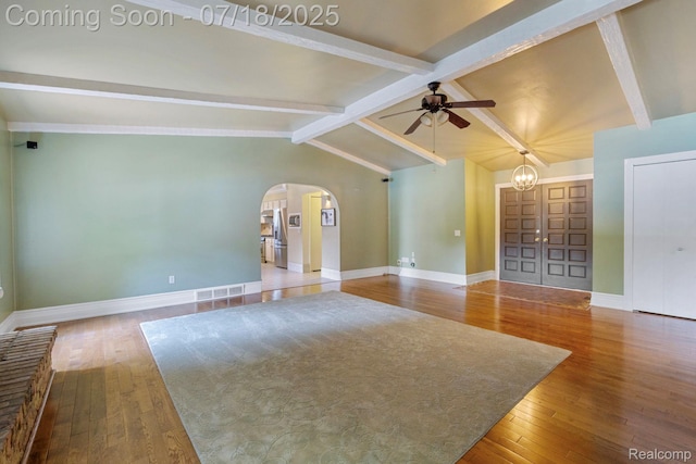 8400 Oak Shade Ct, Davison, MI 48423 - unfurnished living room featuring a ceiling fan, arched walkways, hardwood / wood-style flooring, and a chandelier