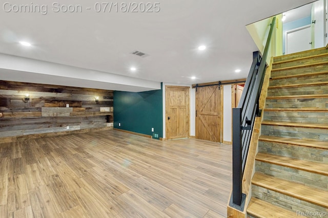 8400 Oak Shade Ct, Davison, MI 48423 - finished below grade area featuring stairs, wooden walls, recessed lighting, light wood-style flooring, and a barn door