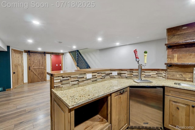 8400 Oak Shade Ct, Davison, MI 48423 - kitchen with open shelves, a barn door, light wood-style flooring, light stone countertops, and recessed lighting