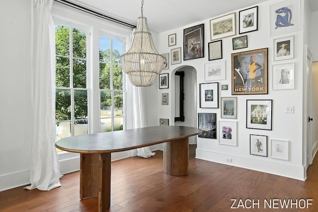 334 Washington Blvd, Holland, MI 49423 - unfurnished dining area featuring dark wood-style flooring, a chandelier, and arched walkways