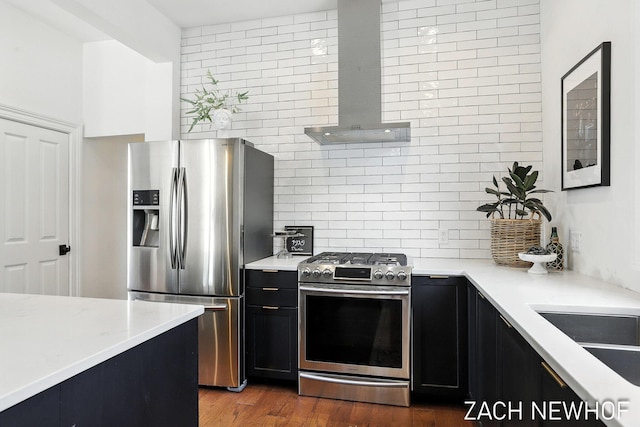 334 Washington Blvd, Holland, MI 49423 - kitchen featuring stainless steel appliances, wall chimney range hood, dark cabinets, and decorative backsplash