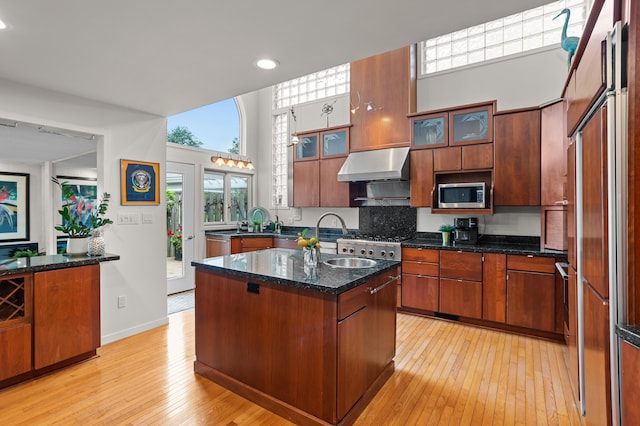 2323 Solano Dr, Wolverine Lake, MI 48390 - kitchen with built in appliances, ventilation hood, light wood-style flooring, a center island, and a high ceiling