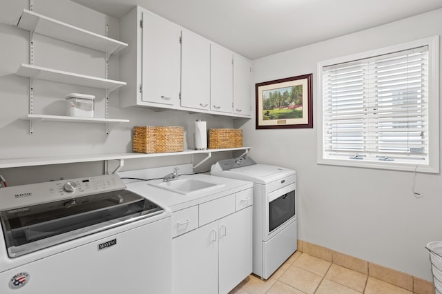 2323 Solano Dr, Wolverine Lake, MI 48390 - laundry area featuring washing machine and dryer, cabinet space, and light tile patterned floors