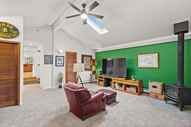 2323 Solano Dr, Wolverine Lake, MI 48390 - living room featuring a wood stove, ceiling fan, baseboard heating, carpet floors, and beamed ceiling