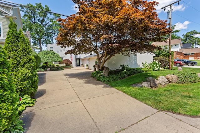 2323 Solano Dr, Wolverine Lake, MI 48390 - view of property hidden behind natural elements featuring concrete driveway, a front lawn, and a garage