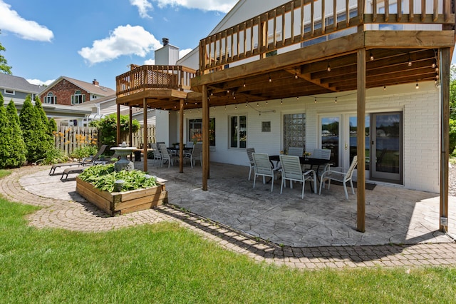 2323 Solano Dr, Wolverine Lake, MI 48390 - back of property featuring brick siding, a deck, a patio, and outdoor dining space
